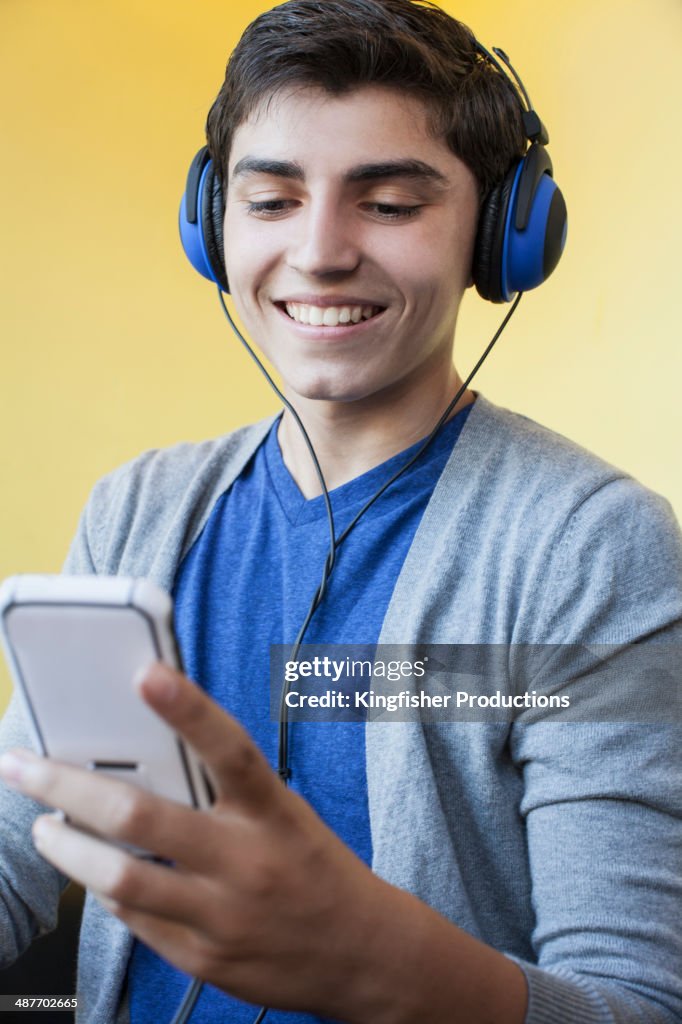 Mixed race teenage boy listening to headphones