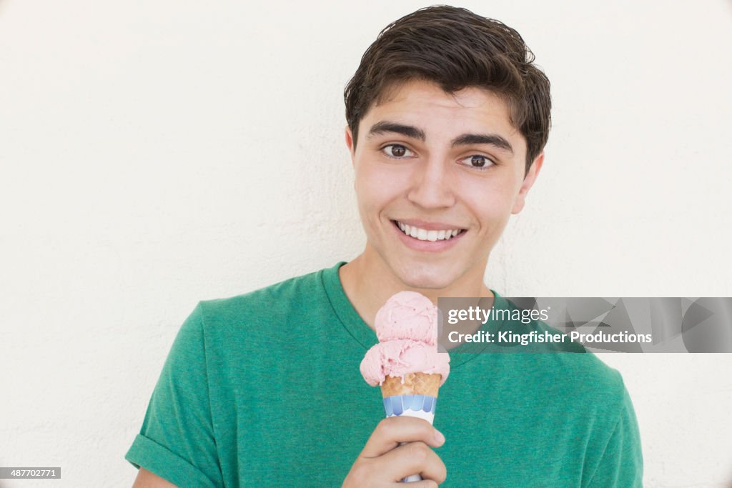 Mixed race teenage boy eating ice cream cone