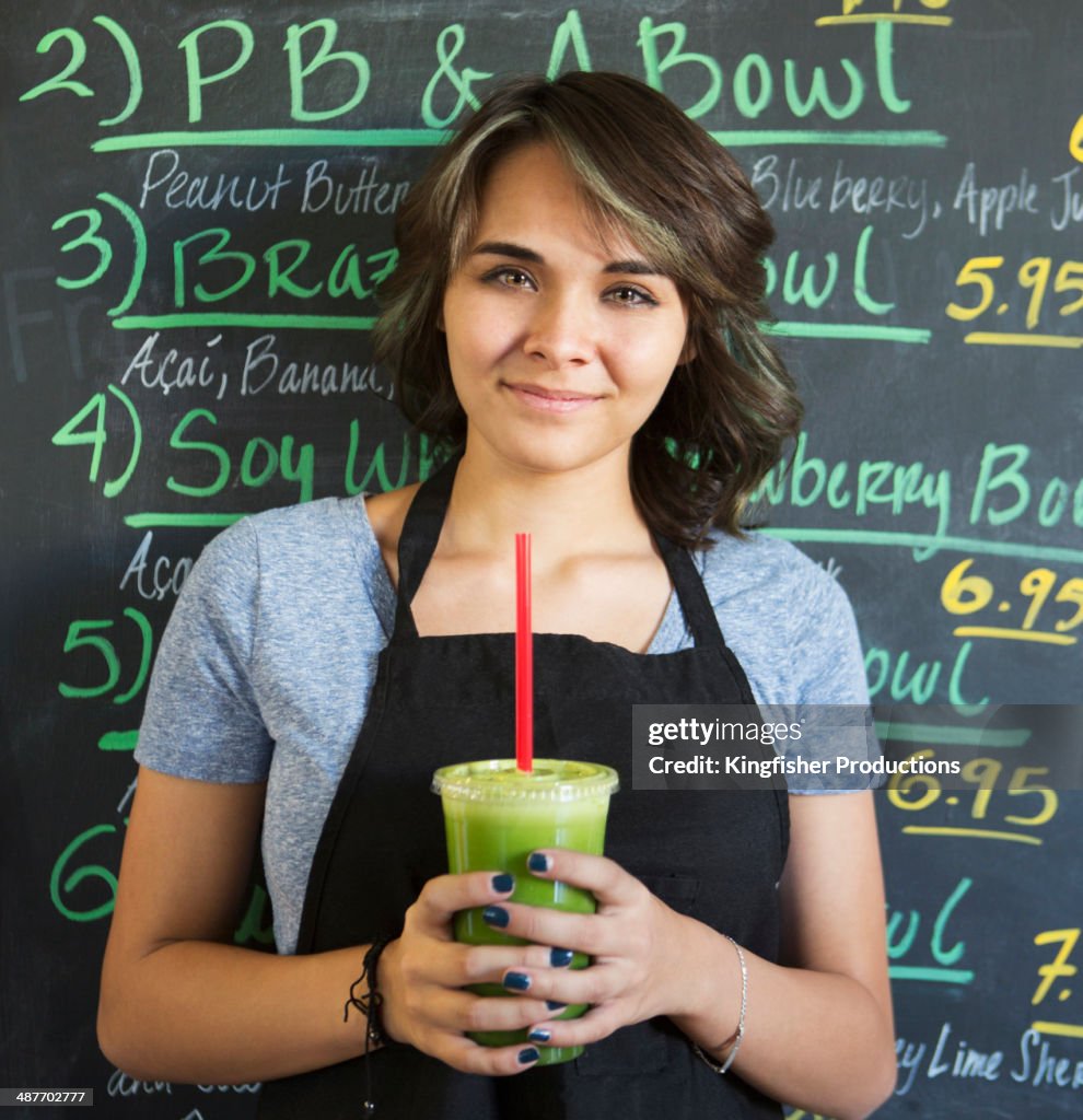 Young woman working in smoothie cafe
