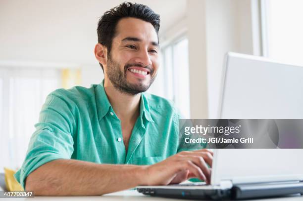 mixed race man using laptop - mid adult men stock pictures, royalty-free photos & images