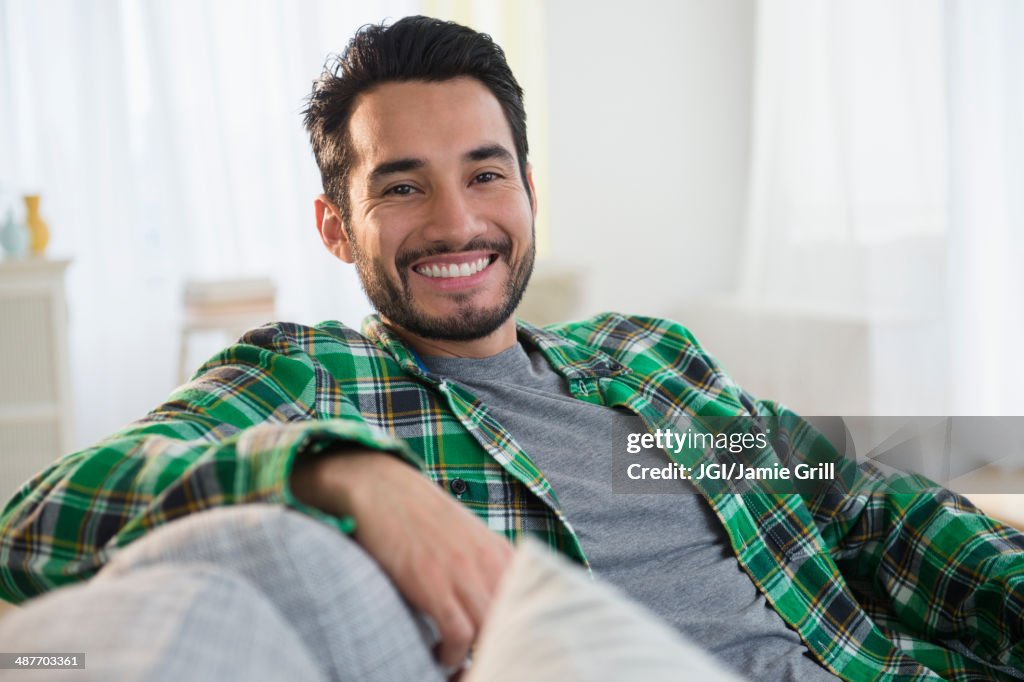 Mixed race man smiling on sofa