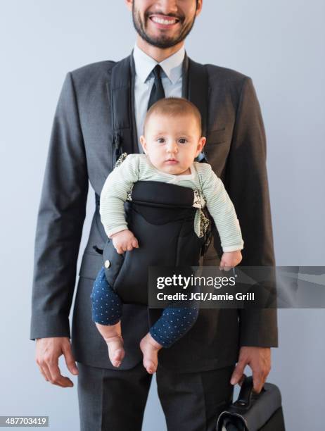 businessman carrying baby in carrier - portabebés fotografías e imágenes de stock