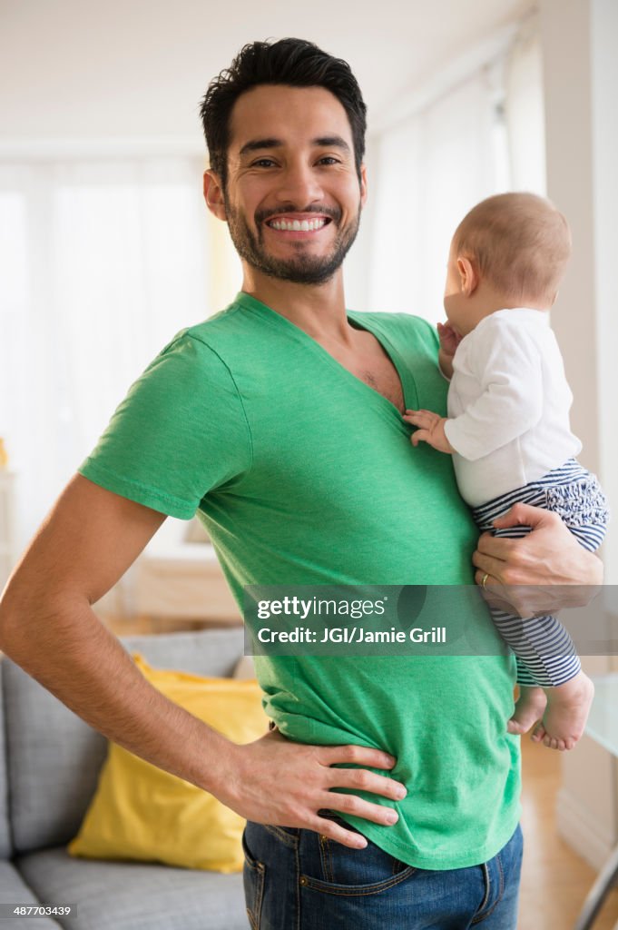 Father holding baby in living room