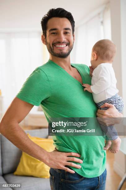 father holding baby in living room - baby superhero stock-fotos und bilder