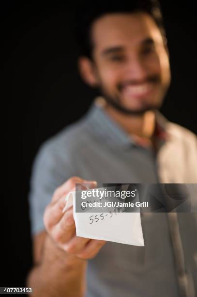 mixed race man giving out phone number on napkin - phone number stock pictures, royalty-free photos & images