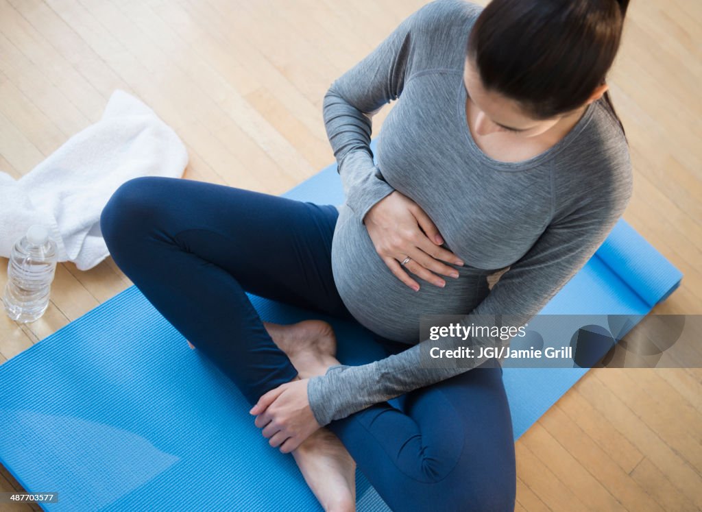 Pregnant Caucasian woman practicing yoga
