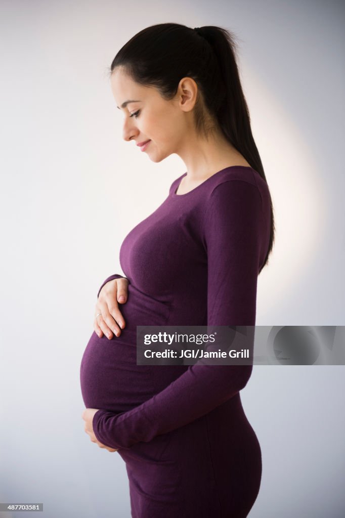 Pregnant Caucasian woman holding stomach