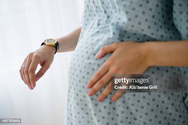 pregnant caucasian woman timing contractions in hospital - muscular contraction stock pictures, royalty-free photos & images