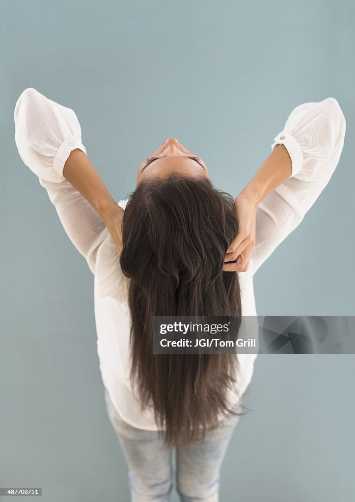 Hispanic woman with long hair leaning back