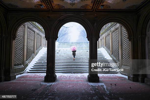 asian woman walking up steps into snow - 33 arches stock pictures, royalty-free photos & images