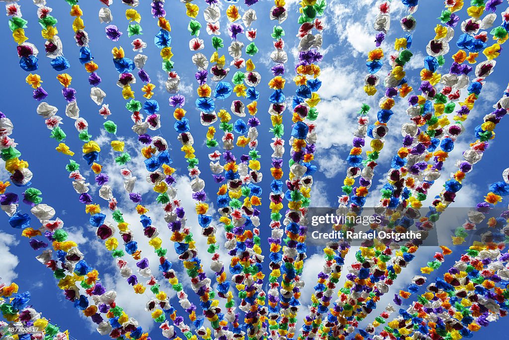 Colourful paper garlands against a blue sky