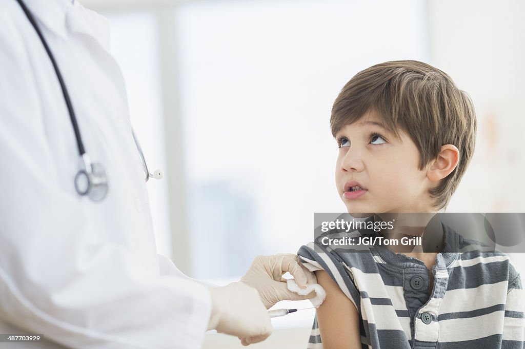 Hispanic boy getting a shot at doctor's office