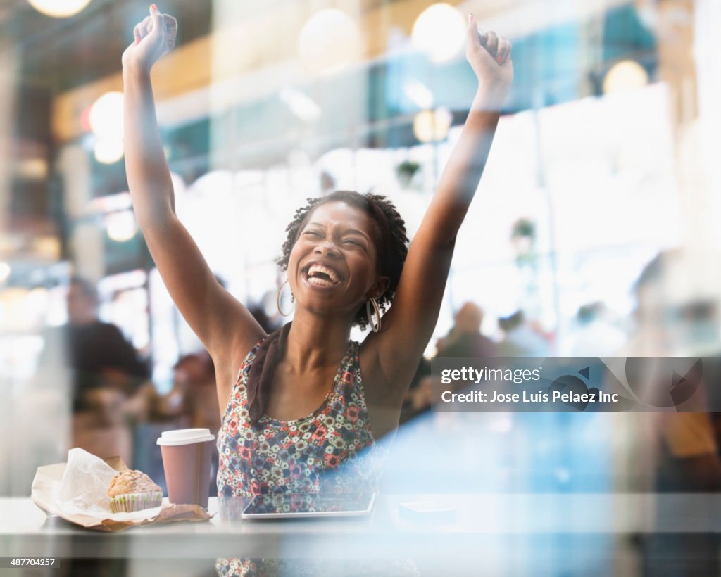 Black woman cheering in cafe