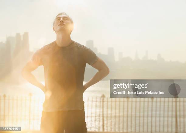 chinese man standing by urban river - west new york new jersey stock-fotos und bilder