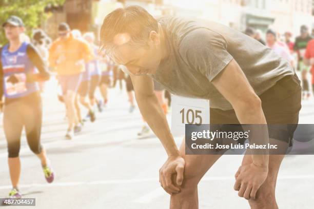 chinese runner resting at finish line - exhausted at finish line stock pictures, royalty-free photos & images