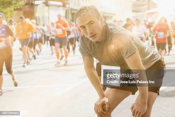 chinese runner resting at finish line - marathon stock-fotos und bilder