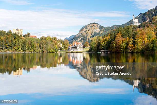 alpsee lake with the royal castles of schloss neuschwanstein and schloss hohenschwangau in autumn, fuessen, east allgaeu, bavaria, germany - schloss neuschwanstein imagens e fotografias de stock