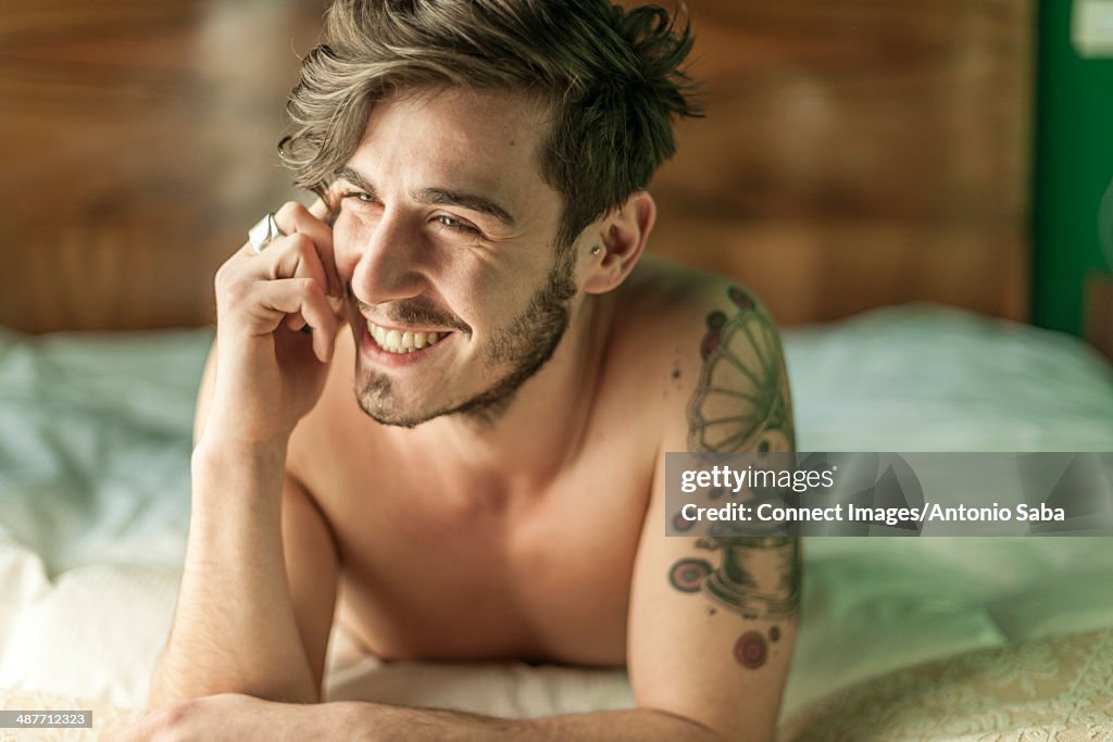 Man using cellular phone in bed