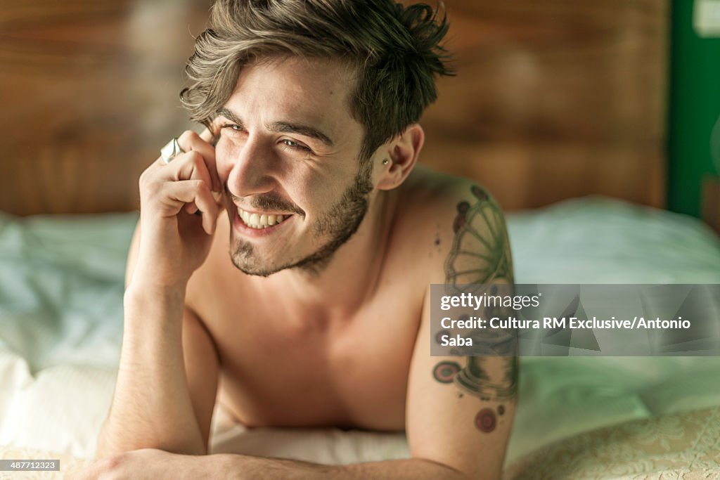 Man using cellular phone in bed
