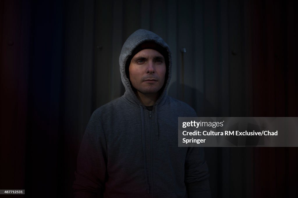 Portrait of mid adult man in front of corrugated fence