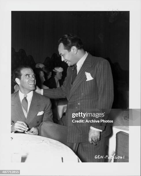 Director Frank Capra and actor Edward G Robinson talking at an awards ceremony, circa 1935-1945.
