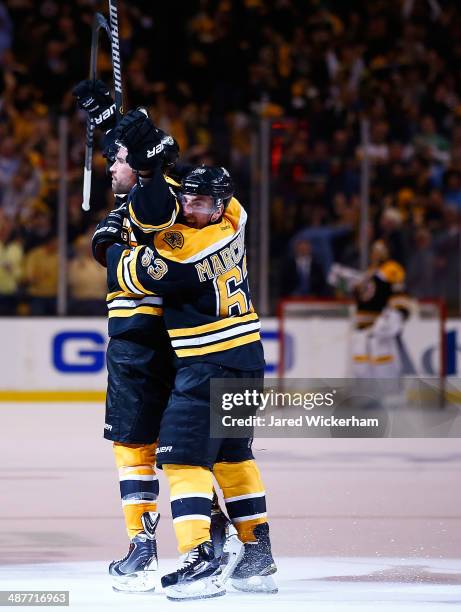 Johnny Boychuk of the Boston Bruins celebrates his goal in the third period with teammate Brad Marchand against the Montreal Canadiens to force...