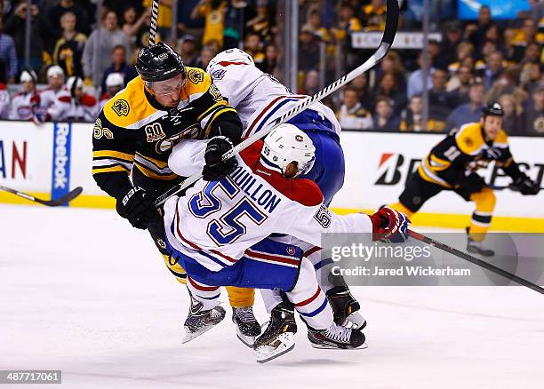 Brad Marchand of the Boston Bruins collides with Francis Bouillon and Alexei Emelin of the Montreal Canadiens in the third period in Game One of the...