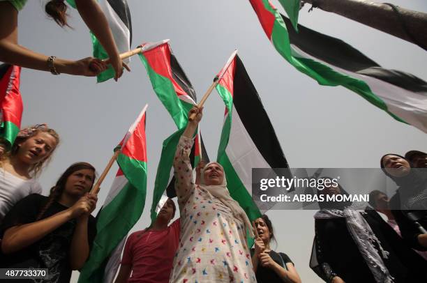 Palestinians celebrate the United Nations General Assembly decision to allow the flag of Palestine -- which has a non-member observer status -- to be...