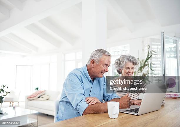 keeping up with modern technology - senior couple laptop stock pictures, royalty-free photos & images