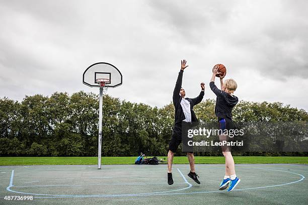 basketball 1v1 man-woman in a london playground - british basketball stock pictures, royalty-free photos & images