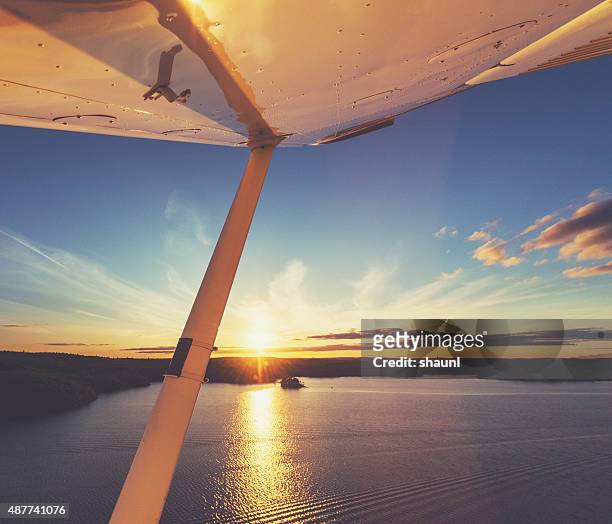 flying in evening skies - propellervliegtuig stockfoto's en -beelden