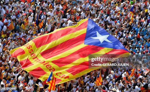 Demonstrators unfold a big "estelada" during celebrations of Catalonia's National Day which recalls the final defeat of local troops by Spanish king...