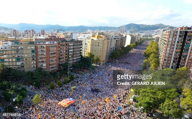 Demonstrators gather on Meridiana street as they wave "Estelada" flags during celebrations of Catalonia's National Day which recalls the final defeat...