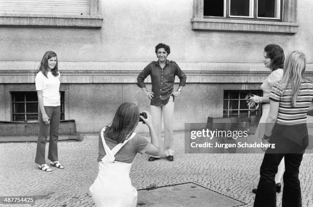 French singer Gilbert Bécaud being photographed by female fans during a visit to West Berlin, Germany, 1971.