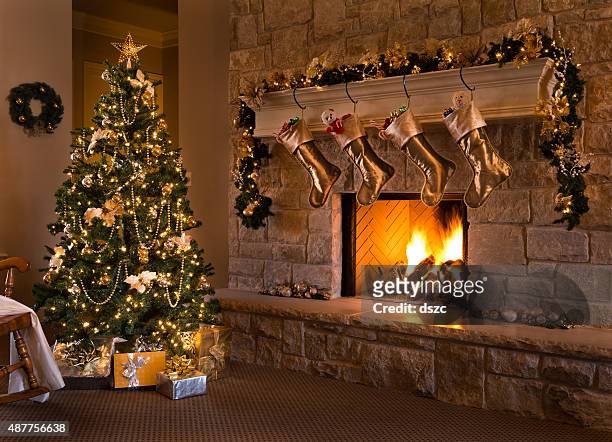 gold theme christmas eve: tree, fireplace, stockings, gifts, mantel, hearth - hanging christmas lights stock pictures, royalty-free photos & images