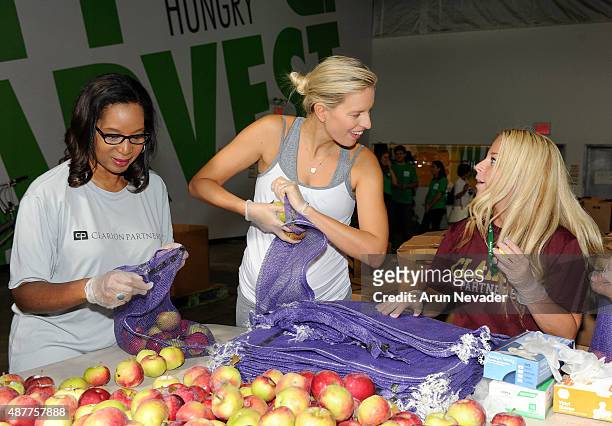 Model Karolina Kurkova volunteers her labor to bag fruit with workers at City Harvest's Food Rescue Facility during Feeding America’s Hunger Action...