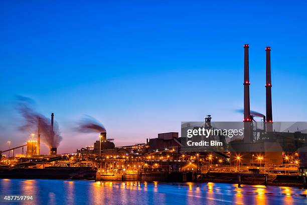 beleuchtete industrielle anlage am fluss bei nacht, amsterdam, niederlande - amsterdam blue sky stock-fotos und bilder