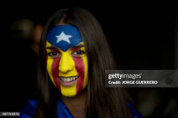 Girl with an "Estelada" painted on her face smiles during celebrations of Catalonia's National Day which recalls the final defeat of local troops by...