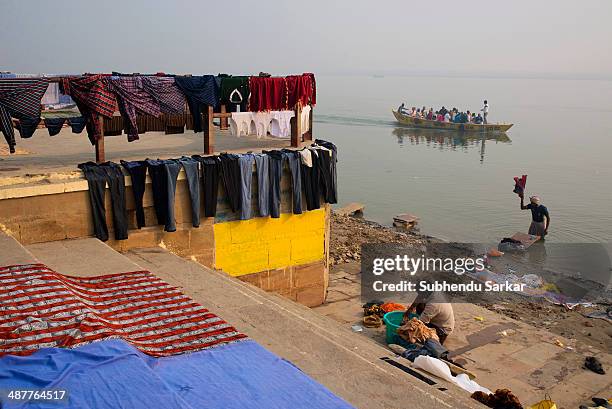 Washermen engaged in washing and drying clothes on the ghats of Varanasi. Varanasi is a holy city on the banks of the Ganges .