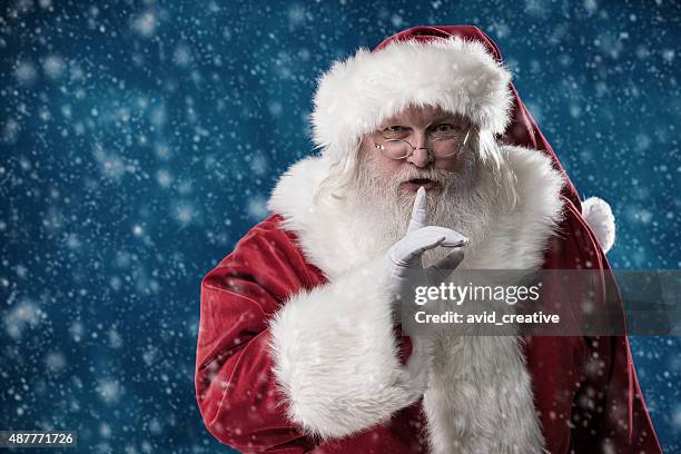 real santa mit finger auf den mund legen - secret santa stock-fotos und bilder