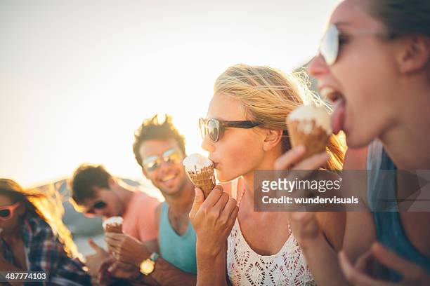 friends eating icecream on beach - girls licking girls stockfoto's en -beelden