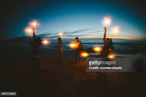 grupo de amigos com fogos de artifício - praia noite imagens e fotografias de stock