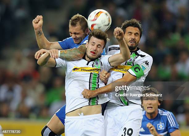 Pierre-Michel Lasogga of Hamburg, Havard Nordveit and Martin Stranzl of Moenchengladbach jump for the ball during the Bundesliga match between...