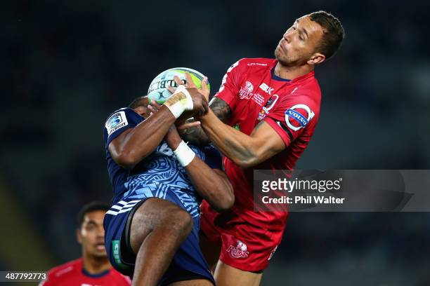 Quade Cooper of the Reds contests the high ball with Lolagi Visinia of the Blues during the round 12 Super Rugby match between the Blues and the Reds...
