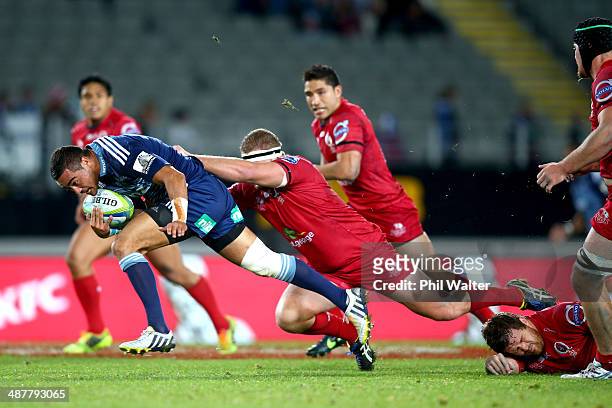 Bryn Hall of the Blues breaks the tackle of James Slipper of the Reds during the round 12 Super Rugby match between the Blues and the Reds at Eden...