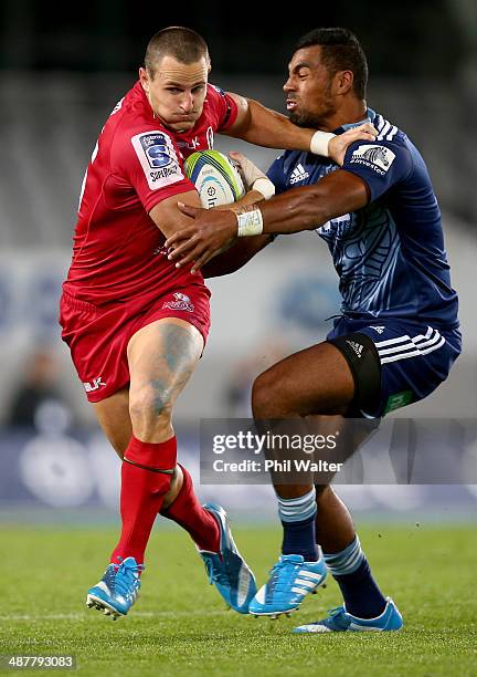 Mike Harris of the Reds is tackled by Lolagi Visinia of the Blues during the round 12 Super Rugby match between the Blues and the Reds at Eden Park...