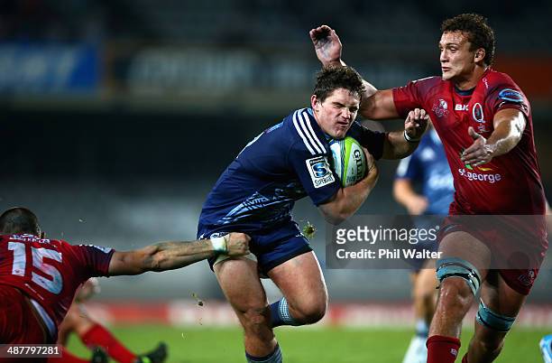 Simon Hickey of the Blues is tackled by Jake Schatz of the Reds during the round 12 Super Rugby match between the Blues and the Reds at Eden Park on...