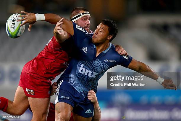 George Moala of the Blues offloads in the tackle of James Hanson of the Reds during the round 12 Super Rugby match between the Blues and the Reds at...