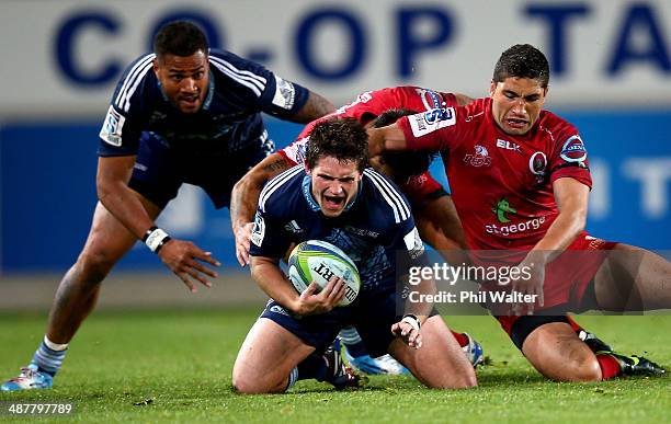 Simon Hickey of the Blues is tackled by Anthony Fainga'a of the Reds during the round 12 Super Rugby match between the Blues and the Reds at Eden...