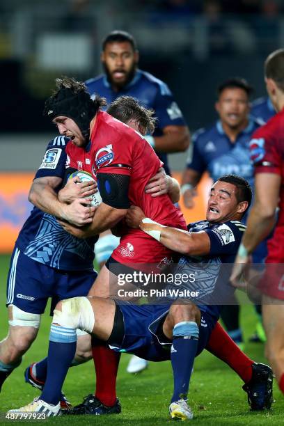 Ben Daley of the Reds is tackled by Bryn Hall of the Blues during the round 12 Super Rugby match between the Blues and the Reds at Eden Park on May...